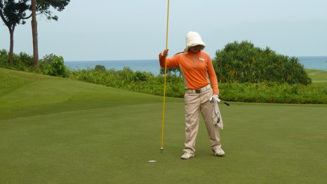 Caddy on the 12th green at Ria Bintan Golf Club Ocean Course