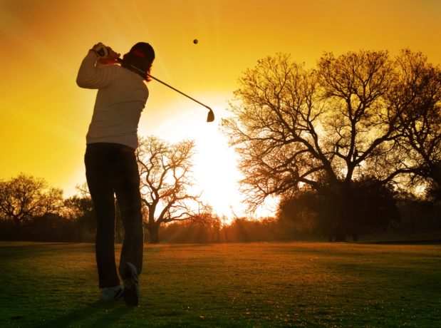 Golfer hitting into the sunset