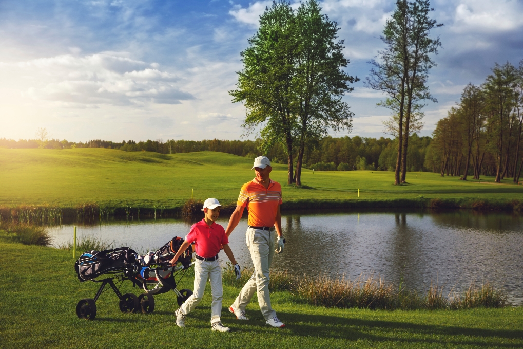 Father and son walking on golf course